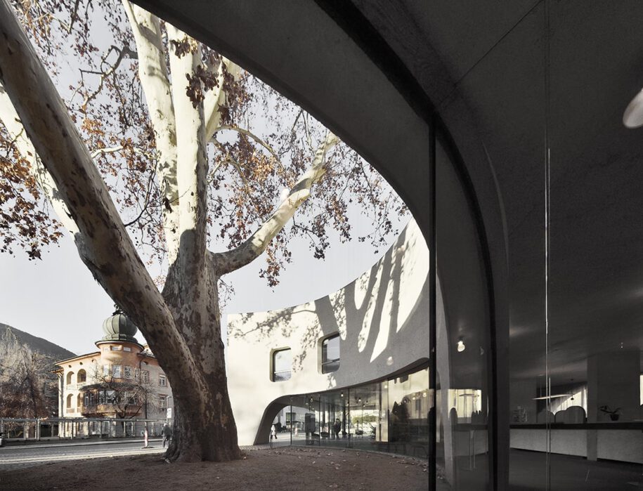 Archisearch TreeHugger : a bold concrete building by MoDusArchitects wraps public space with sinuous curves