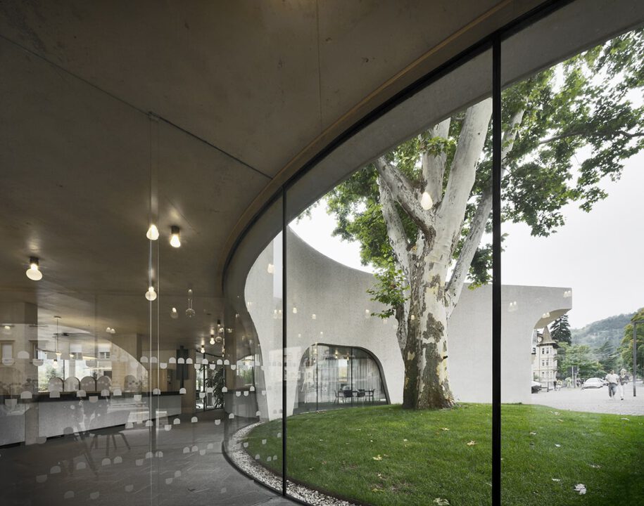 Archisearch TreeHugger : a bold concrete building by MoDusArchitects wraps public space with sinuous curves