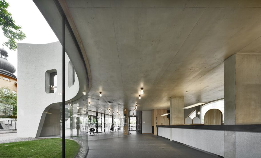 Archisearch TreeHugger : a bold concrete building by MoDusArchitects wraps public space with sinuous curves