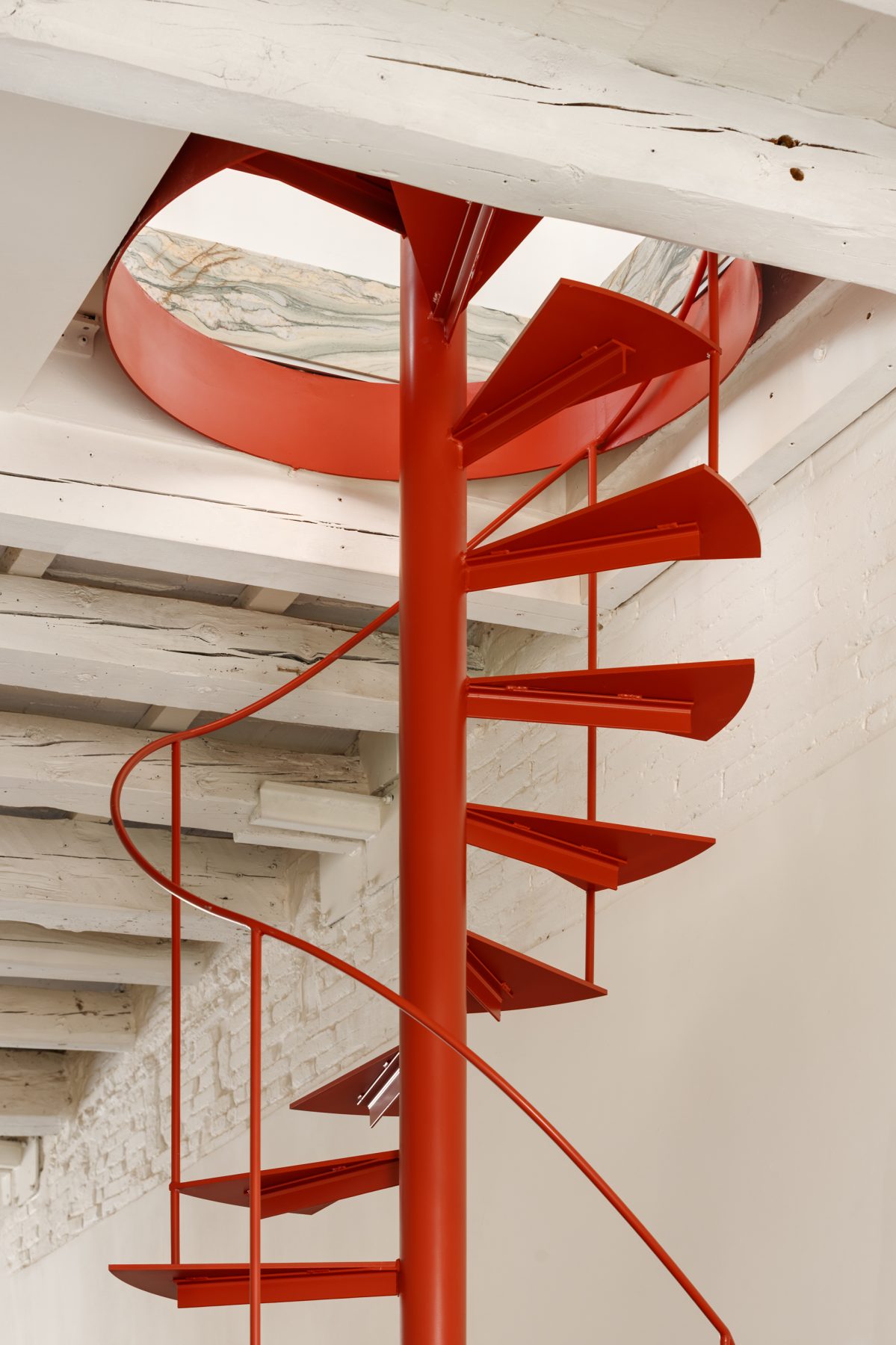 Archisearch Interiors We Love: RiC 12 by Serboli is A Duplex in Barcelona Unfolding Around a Signature Red Spiral Staircase