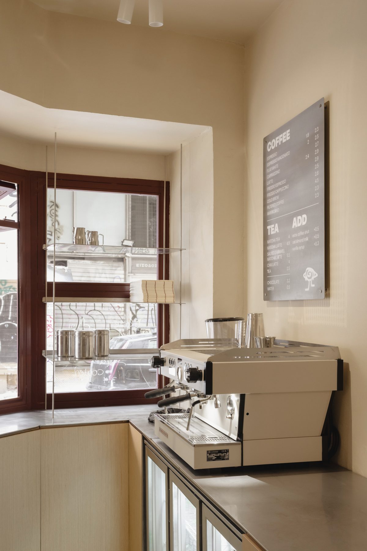 Archisearch Georgios Apostolopoulos designs Ugly Rolls, a tiny corner shop in Athens with cinnamon-toned maroon framing