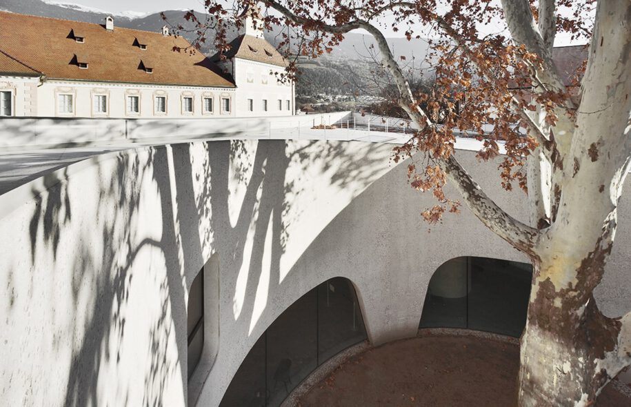 Archisearch TreeHugger : a bold concrete building by MoDusArchitects wraps public space with sinuous curves