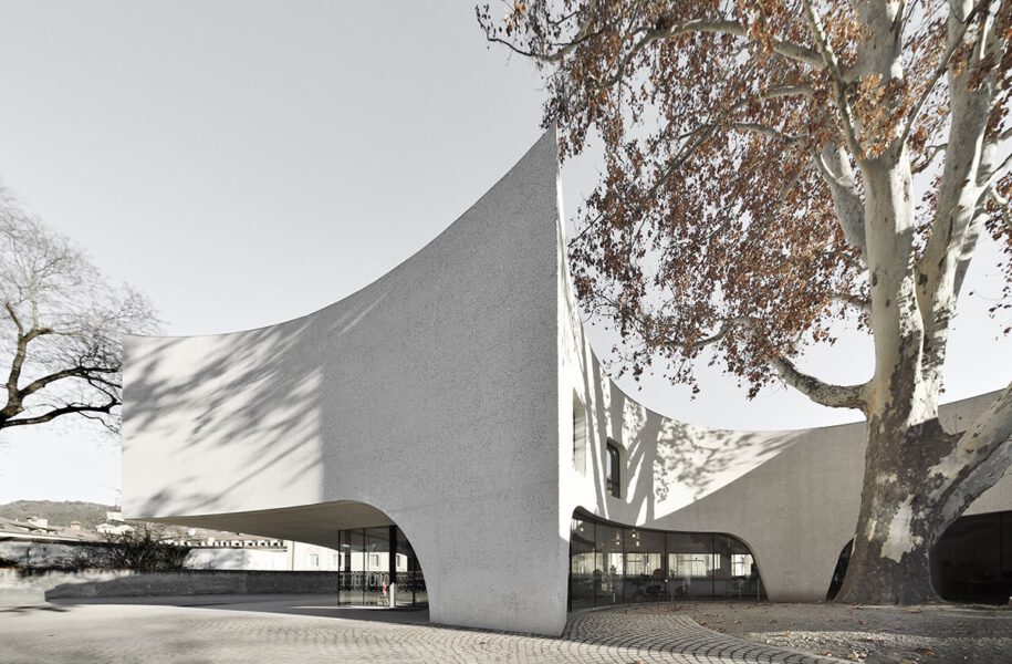 Archisearch TreeHugger : a bold concrete building by MoDusArchitects wraps public space with sinuous curves