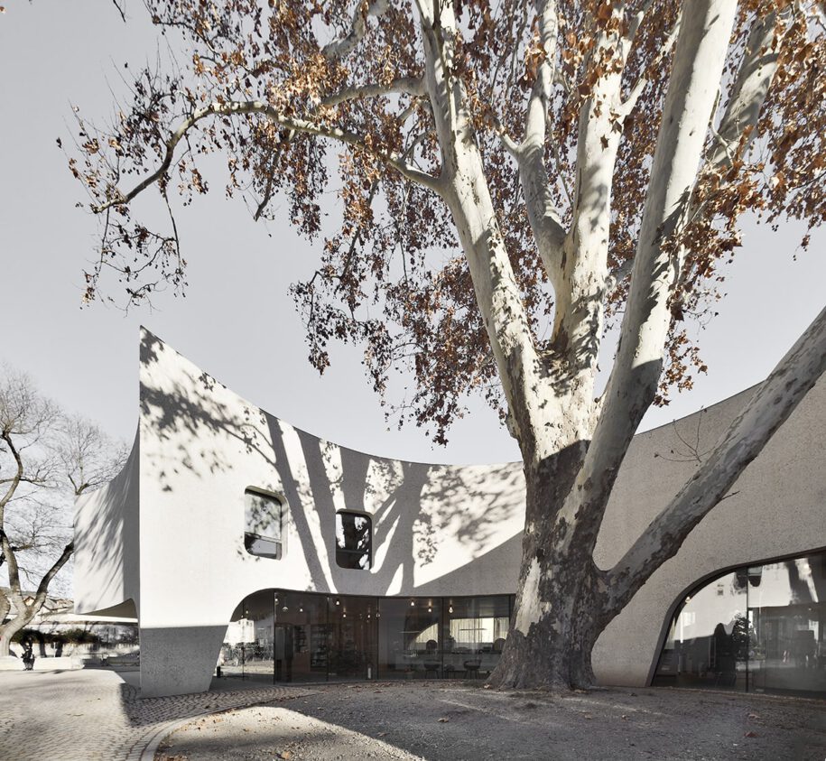 Archisearch TreeHugger : a bold concrete building by MoDusArchitects wraps public space with sinuous curves